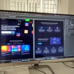 Designer sketching a website landing page layout on paper next to a laptop